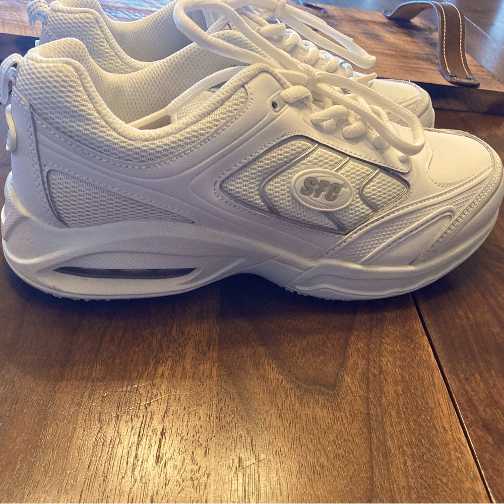 These are white, size 8.5 women’s, and the brand is “shoes for crews”